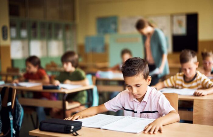 Elementary students learning in classroom with focus on hearing and communication Audiology Planet